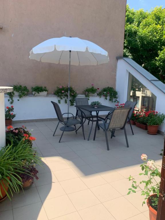 un patio avec une table, des chaises et un parasol dans l'établissement Florence Studio, à Varna
