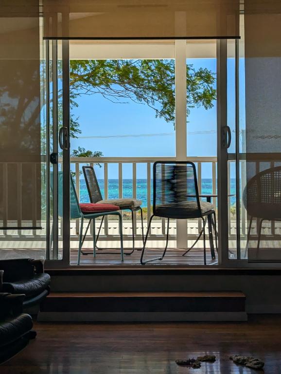 two chairs sitting on a porch with a view of the ocean at Beachside Chateau West Busselton in Busselton