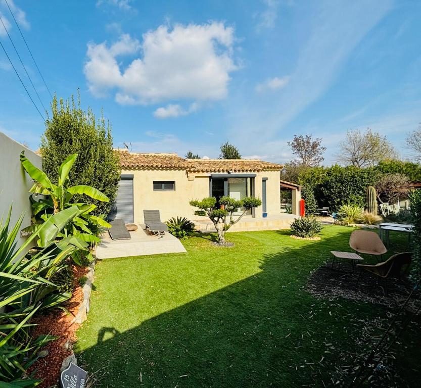 une maison avec une cour avec de l'herbe verte dans l'établissement Joli Villa à 10 min de la plage, à Grimaud