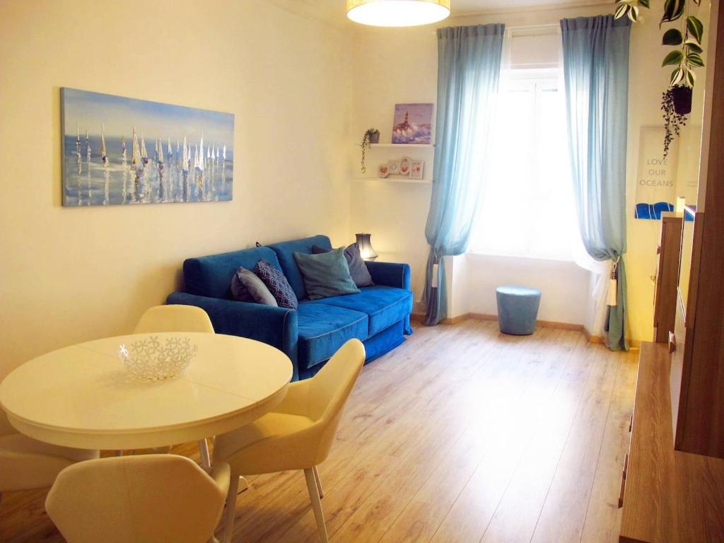 a living room with a blue couch and a table at Blue House Termini-Colosseo in Rome