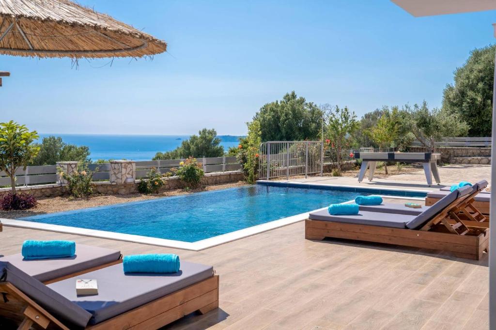a swimming pool with two chaise lounges and a swimming pool at Villa Roz by Villa Plus in Plateies