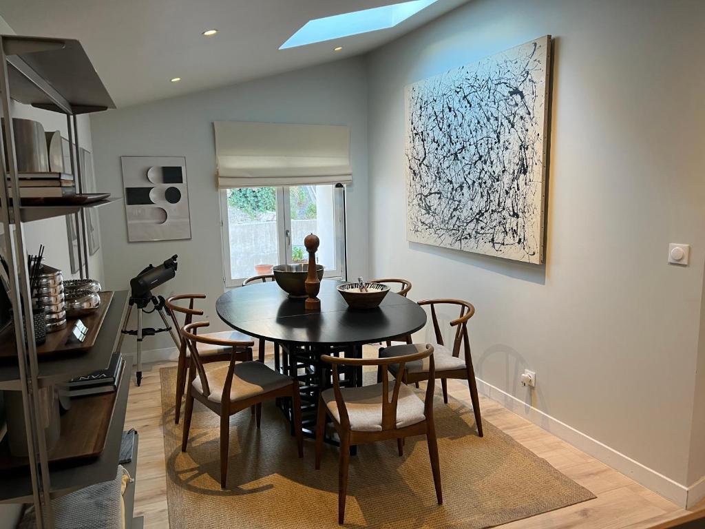 a dining room with a black table and chairs at DURANCE in La Brillanne