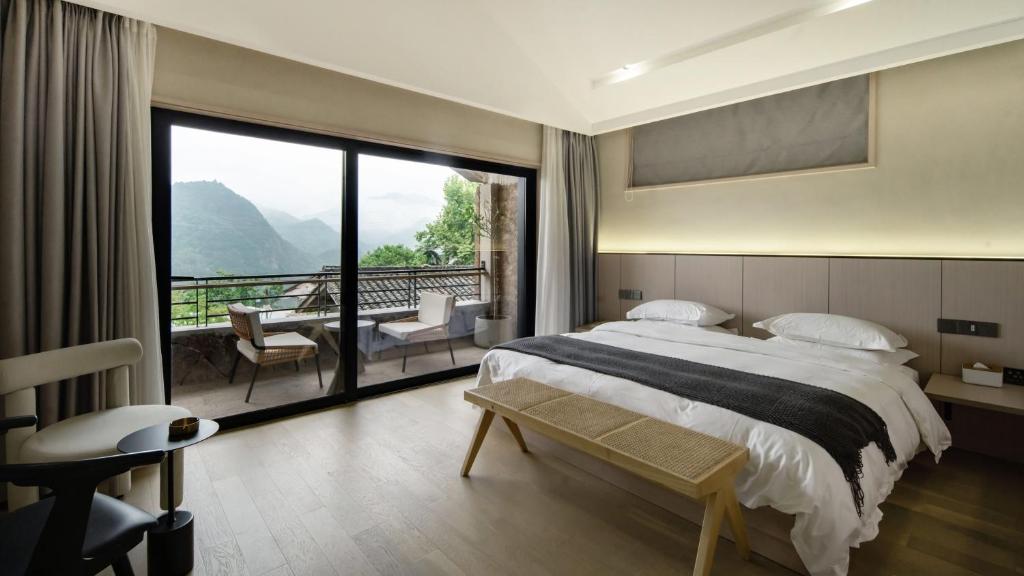 une chambre avec un grand lit et un balcon dans l'établissement Wuyi Zizai Valley Homestay, 