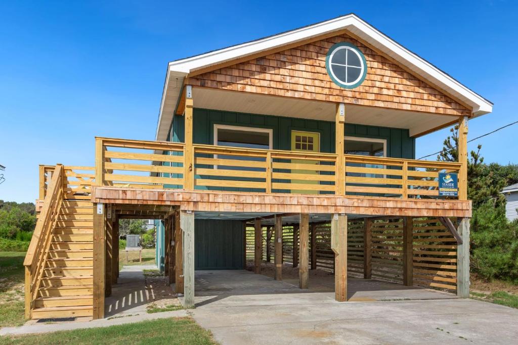 a house with a wrap around porch with a wrap around deck at 4086 - The Wren's Nest in Kitty Hawk