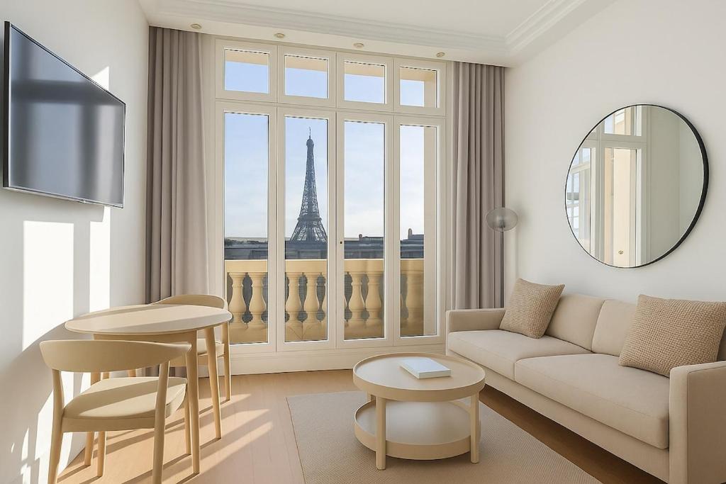 - un salon avec un canapé et une vue sur la tour Eiffel dans l'établissement Suite Avenue des Champs-Élysées, à Paris