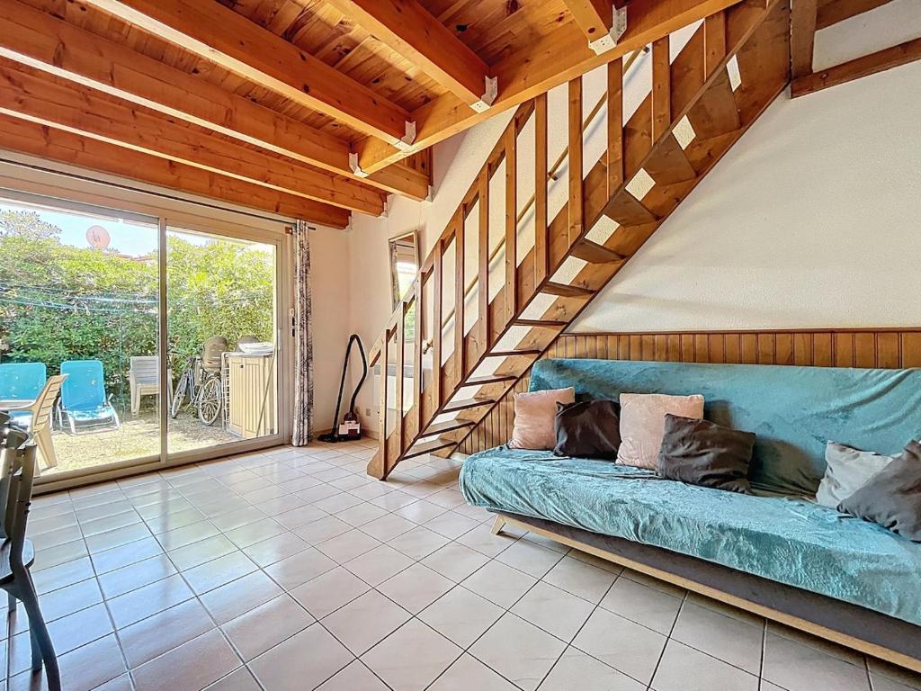 un salon avec un canapé et un escalier dans l'établissement La Rive - Maison de vacance proche de la plage, à Leucate