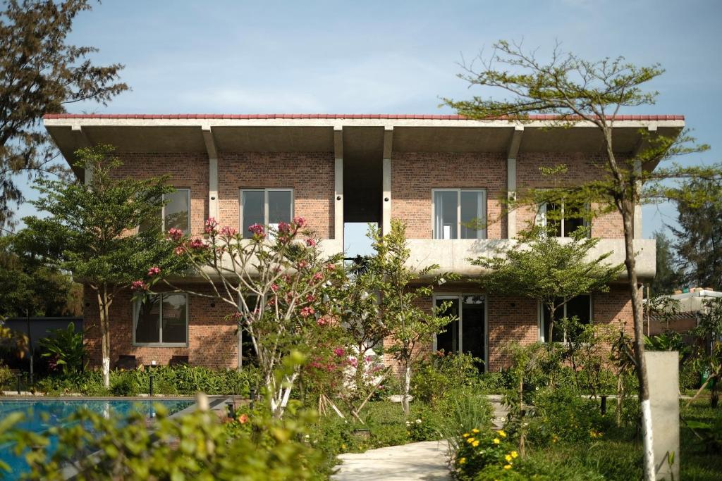 a brick house with a garden in front of it at Sea to Sea Villa Boutique in Hue