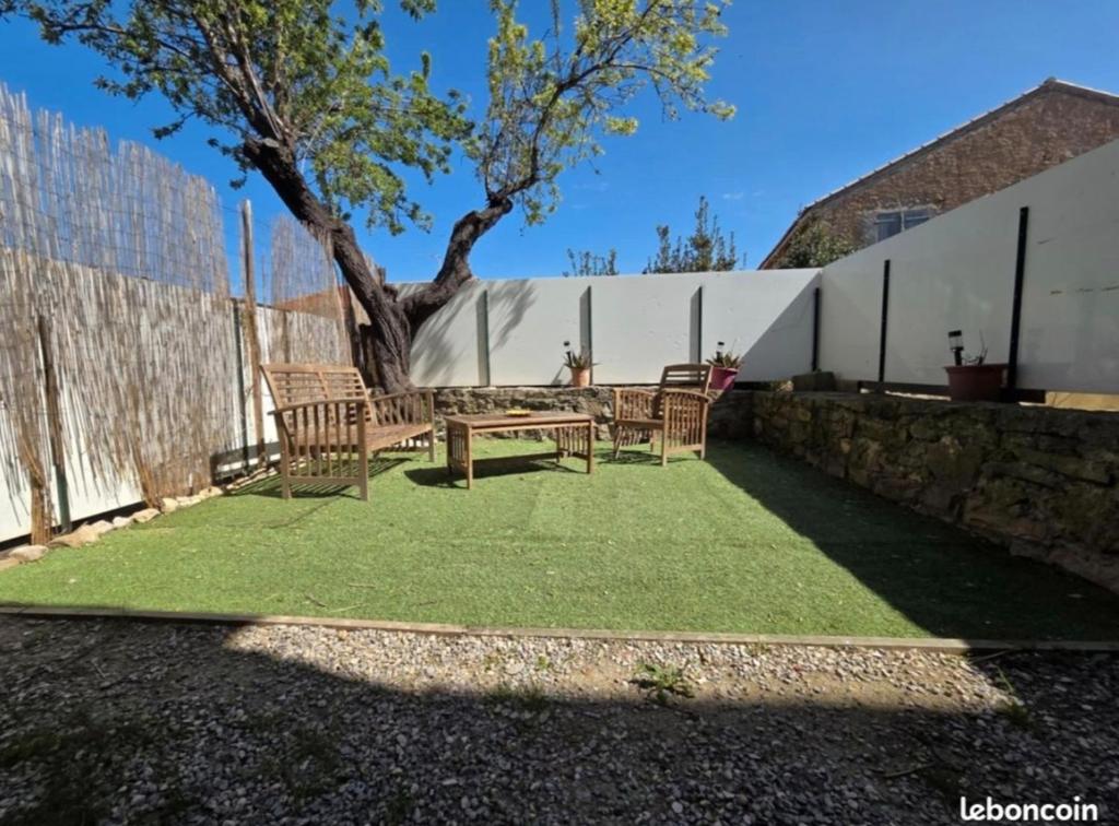 a patio with chairs and a table and a tree at La Quarantaine in Quarante
