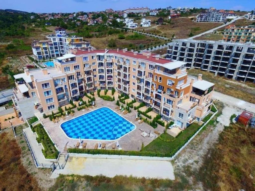 eine Luftansicht eines Apartmentkomplexes mit einem Pool in der Unterkunft Апартамент Бяла in Byala