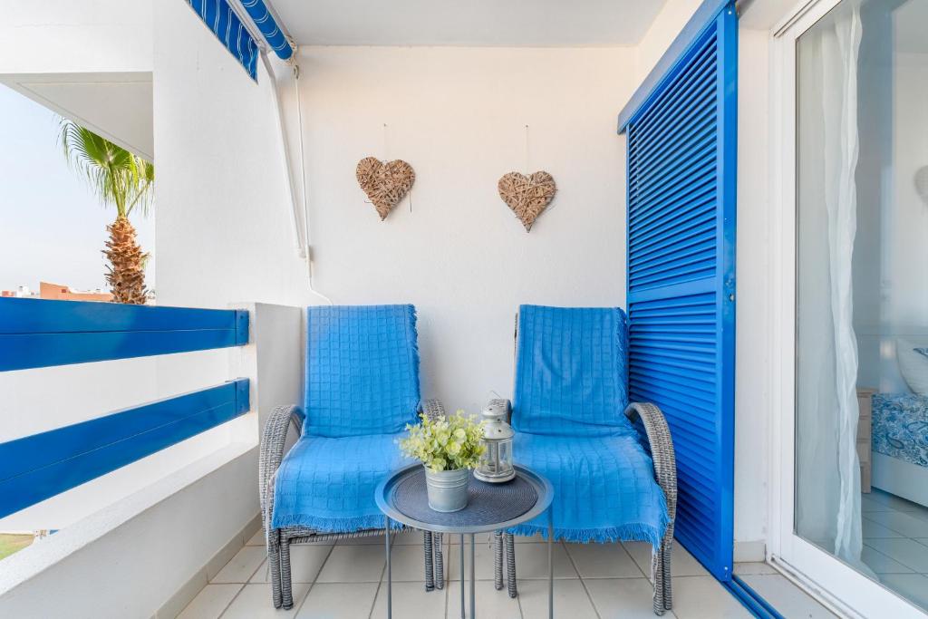 two chairs and a table on a balcony with hearts on the wall at Apartment In Playa Flamenca in Playa Flamenca