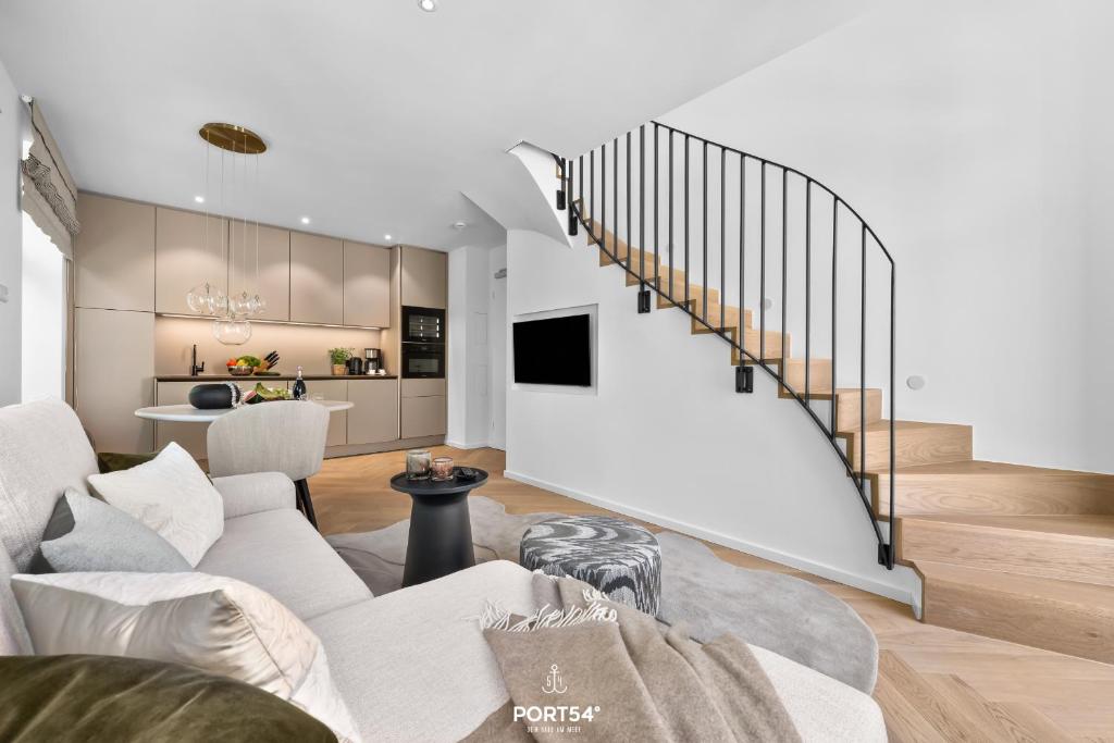 a living room with a couch and a staircase at Maybach Suite Westerland auf Sylt in Westerland