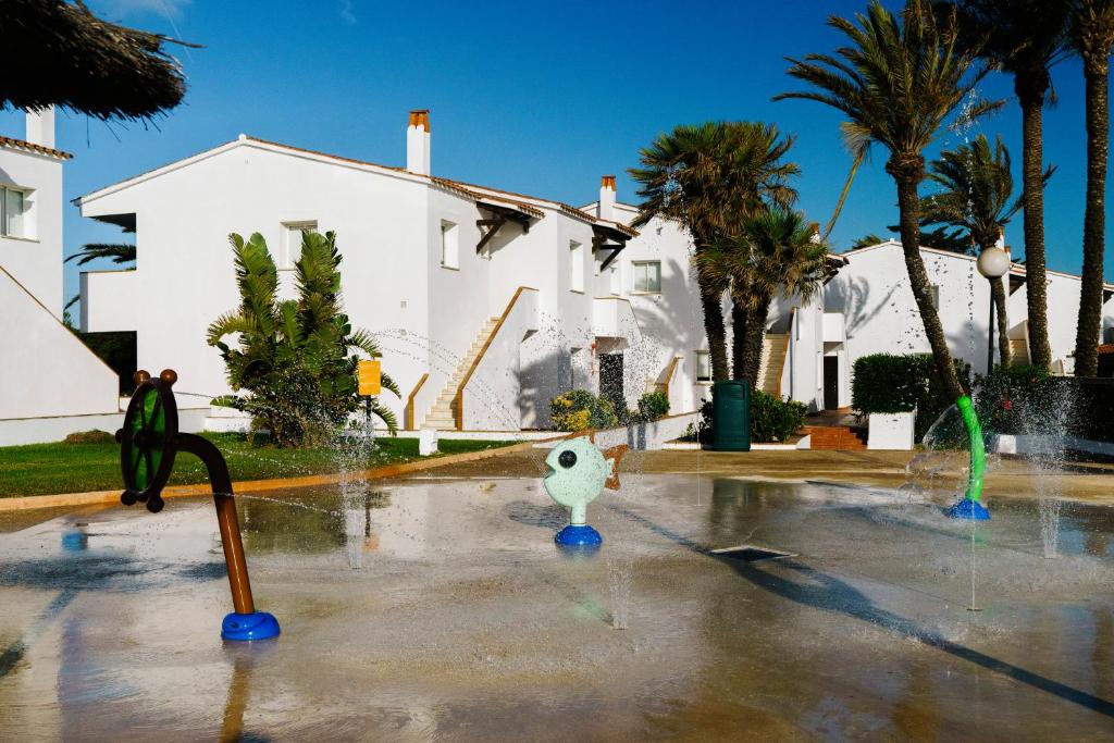 a water fountain in front of a white house at AluaSun Mediterráneo in S'Algar