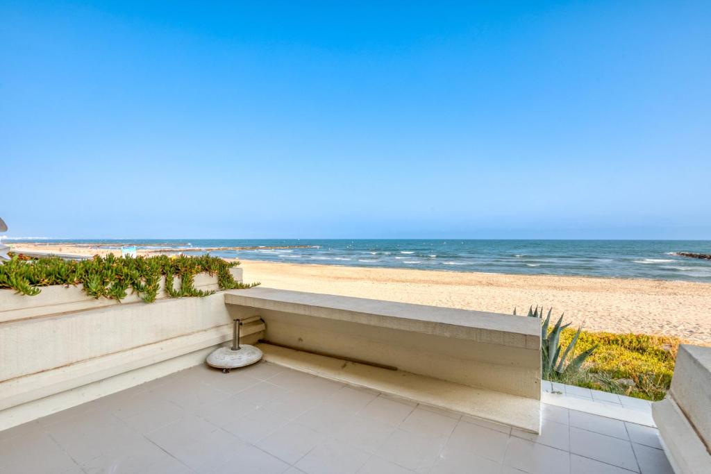 - un banc sur un balcon donnant sur la plage dans l'établissement Première Ligne Avec Terrasse, à Mauguio