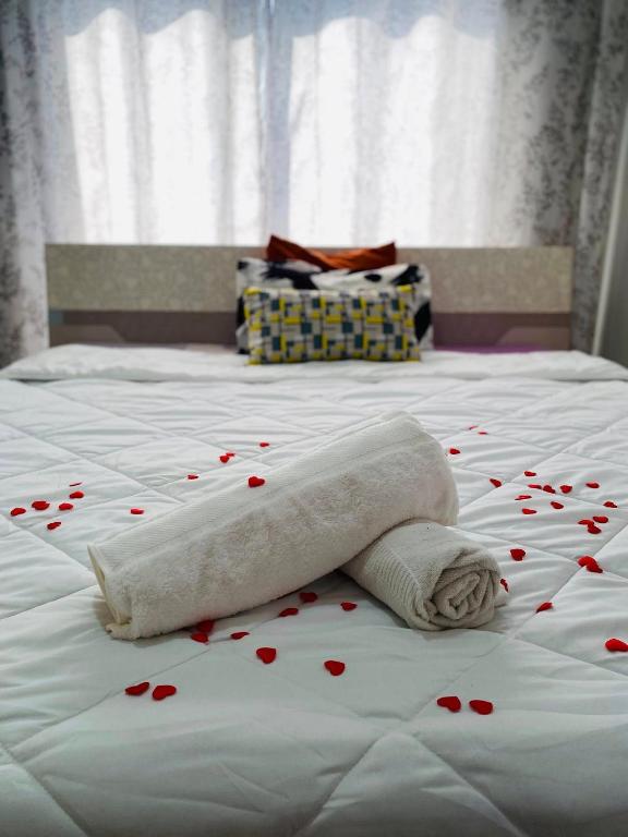 un letto con un asciugamano decorato con cuoricini di RAMI Appart a Antananarivo