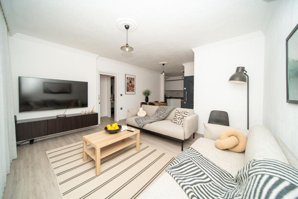 a living room with a couch and a table at Bodrum Center 2 Bedroom Calm Modern Upstairs Flat - Yeni Dünya Bodrum in Bodrum City