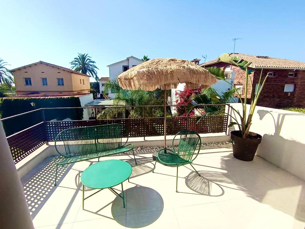 a patio with two chairs and a table and an umbrella at Oceanfront apartment in Premiá de Mar
