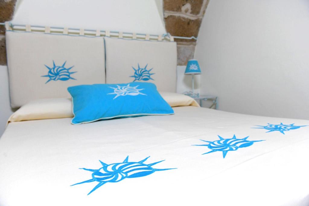 a bed with blue crab pillows on it at HABITATIO MALLORCa in Alghero