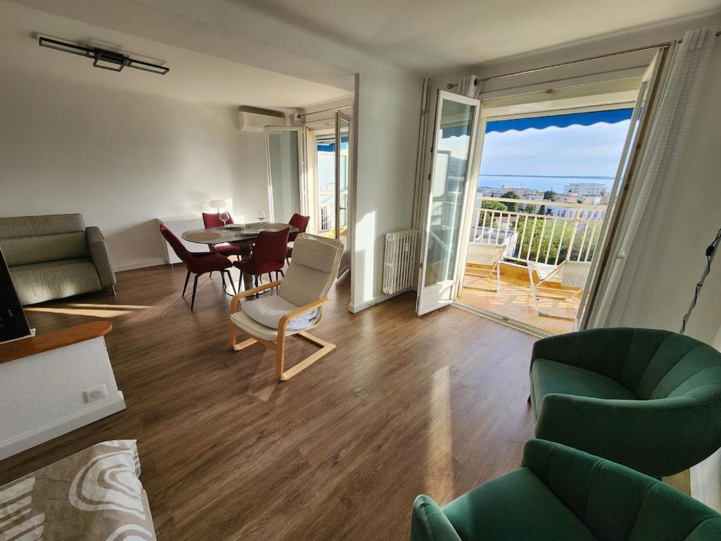 un salon avec un canapé, une table et des chaises dans l'établissement Élégance et mer à Juan-les-Pins, à Antibes