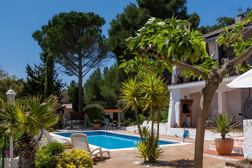 une piscine dans une cour avec des palmiers dans l'établissement Havre De Paix Domaine De Montpins, à Espira-de-lʼAgly