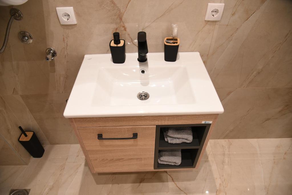 a bathroom sink with two bottles on top of it at L&L Apartman in Smederevska Palanka