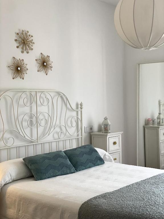 a bedroom with a white bed with flowers on the wall at VUT LOS CONDES Garaje privado in Zamora