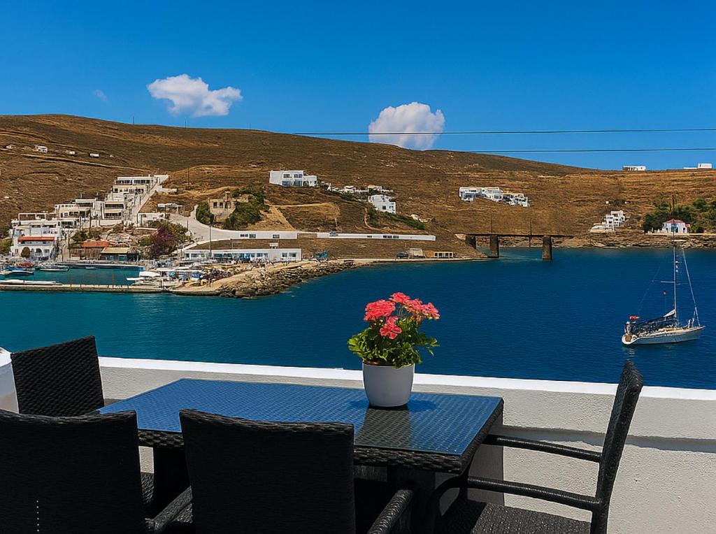 Una mesa con un jarrón de flores en un patio. en Alos Seafront Gem - Loutra Seaview Escape, en Loutra