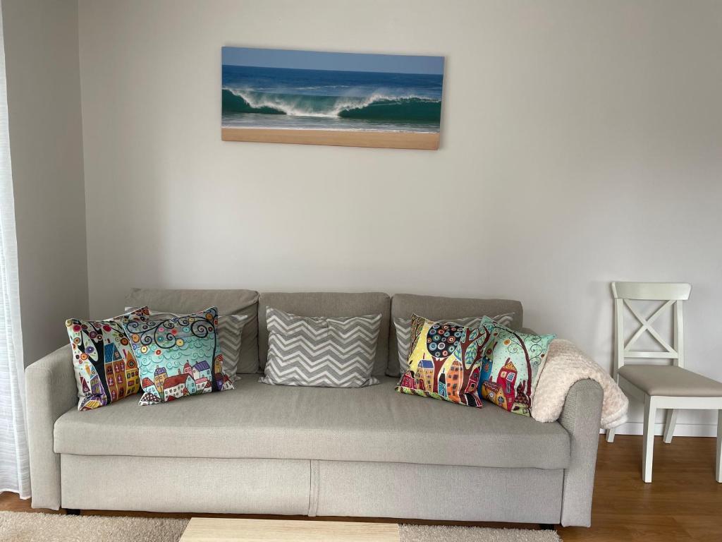 - un canapé gris avec des oreillers dans le salon dans l'établissement Villa Dona Rosa - Viana do Castelo, à Viana do Castelo