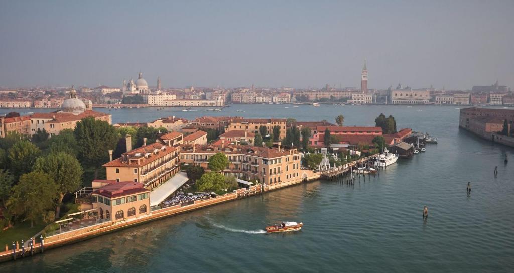 a river with buildings and a boat in the water at Hotel Cipriani, A Belmond Hotel, Venice in Venice