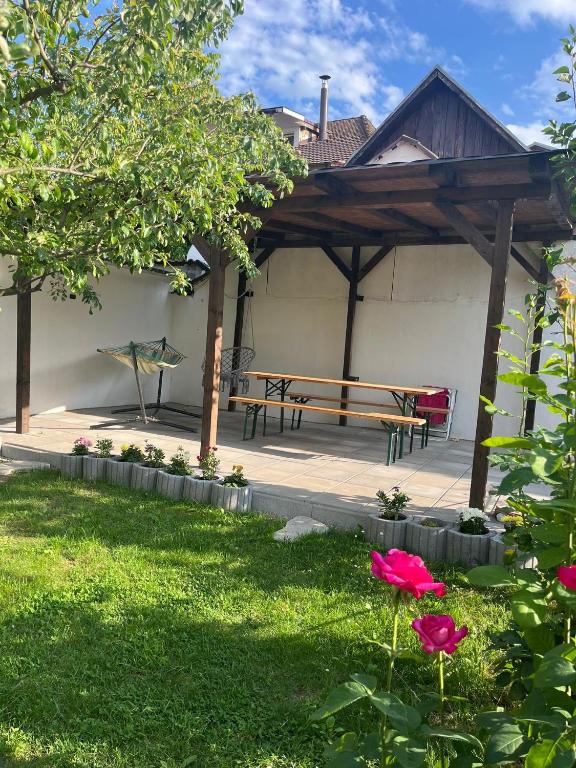 a pavilion with a picnic table and a bench at Casa Primaverii in Râşnov