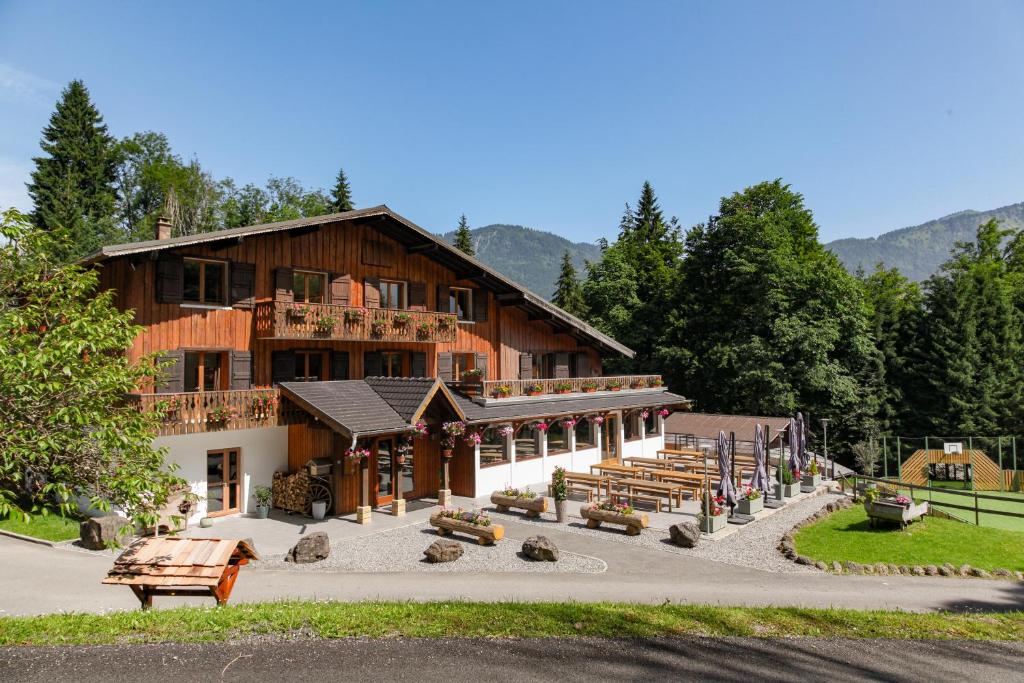un grand bâtiment en bois avec drapeaux devant lui dans l'établissement Chalet le Sauvageon, à Morillon