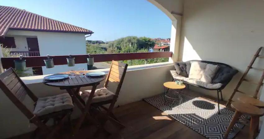 un balcon avec une table et des chaises sur un balcon dans l'établissement T2 résidence avec piscine et tennis, à Bidart