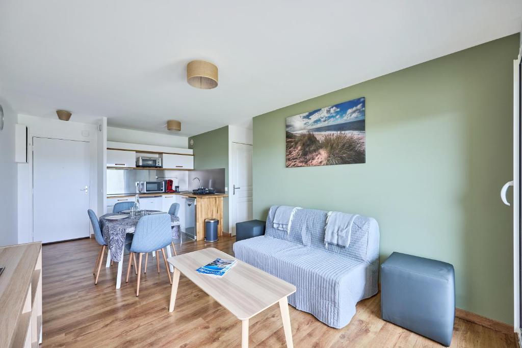 un salon avec un canapé et une table dans l'établissement Les Hirondelles - 800 m de la plage, à Courseulles-sur-Mer