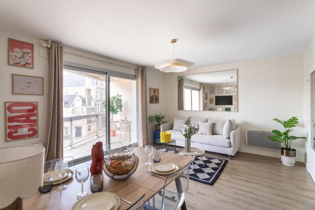 un salon avec une table et un canapé dans l'établissement Le Sedna - Quelques pas de la Plage de l’Écluse, à Dinard