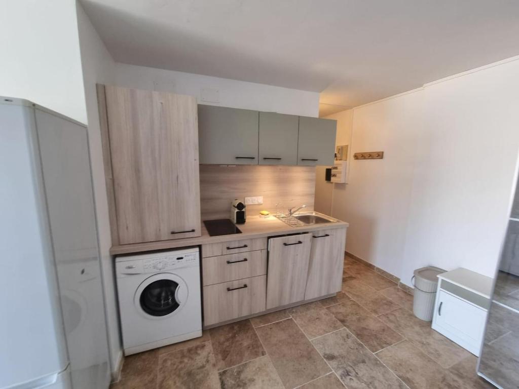 une cuisine avec un lave-linge et un lave-linge dans l'établissement Le Sunrise - Appartement à deux pas de la plage, à Narbonne
