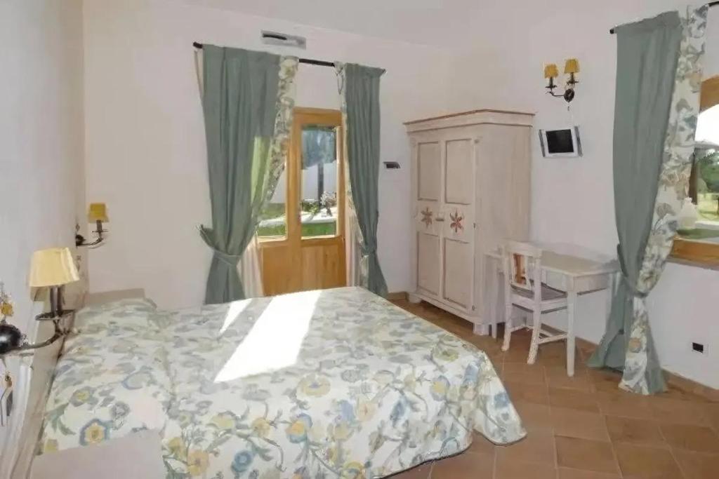 a bedroom with a bed and a desk and a window at Il Casale Mancini in Vada