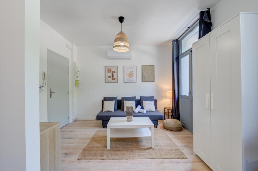 un salon avec un canapé bleu et une table dans l'établissement Jacinthe - 2V - Bureau - Wifi, à Tours