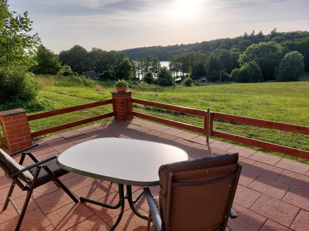 a table and chairs on a patio with a view of a field at Appartementhof Fastnacht am See in Leuengarten