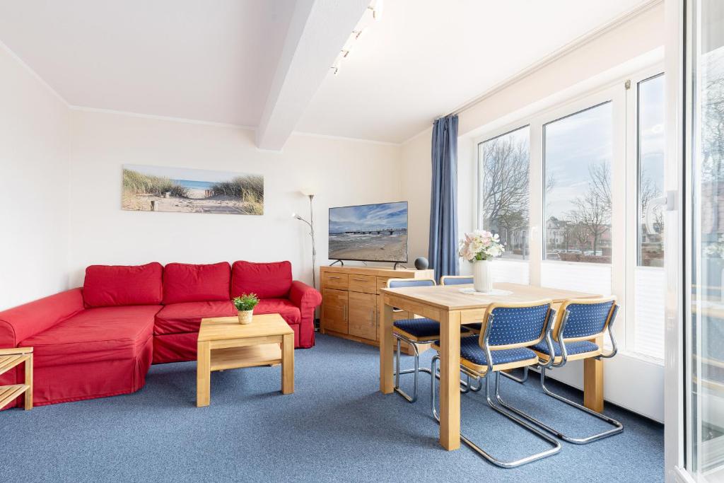 a living room with a red couch and a table at Haus Panorama Laboe Nr 1 in Laboe