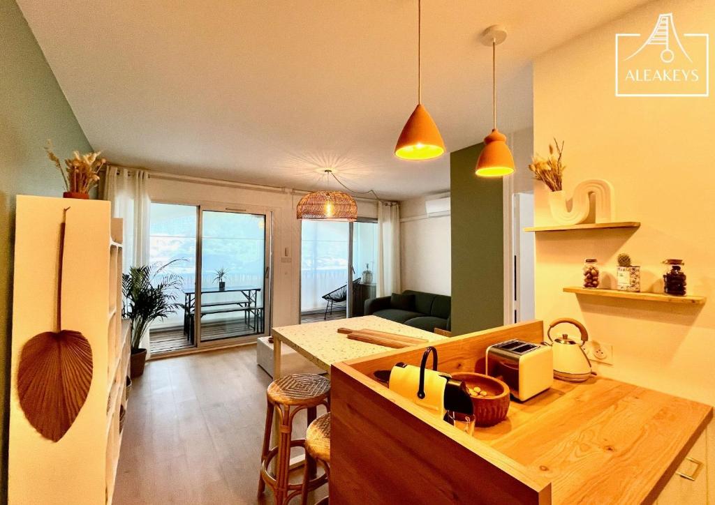 Il dispose d'une cuisine et d'un salon avec un réfrigérateur et une table. dans l'établissement L'Alizés T2 rénové avec clim, parking, Wi-Fi, accès plage directe, à La Grande Motte