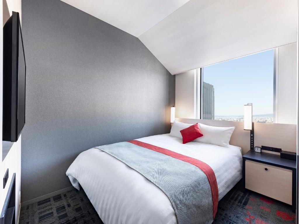 Postel nebo postele na pokoji v ubytování Hotel Hankyu RESPIRE OSAKA