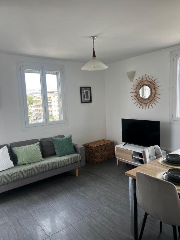 un salon avec un canapé et une télévision dans l'établissement Juan Les Pins 2BR Sunny Top Floor 50m Beach Central, à Antibes