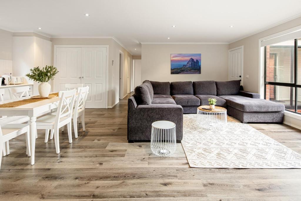 a living room with a couch and a table at Summery 3BR Home by Mel Airport, CBD & Watergardens in Sydenham