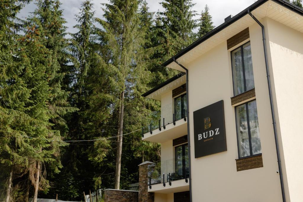 a building with a bulka sign in front of trees at Budz Карпати in Bukovel
