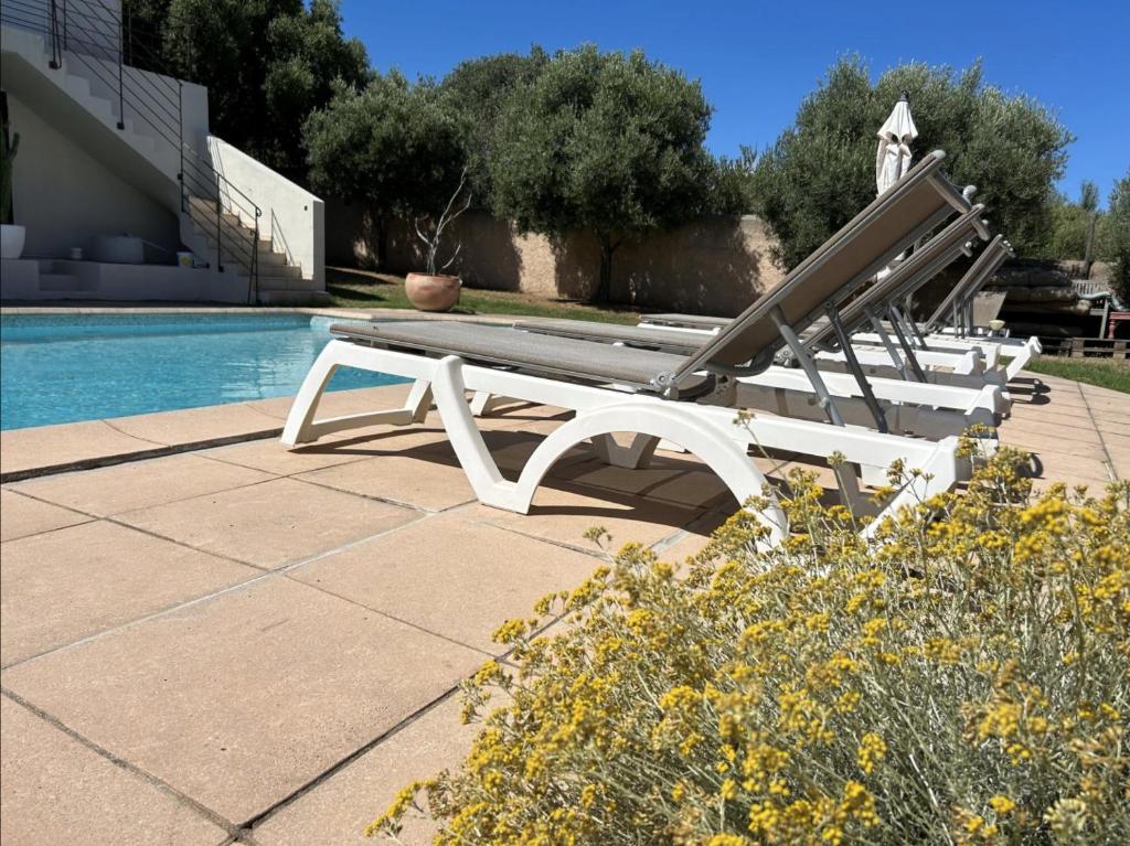 un banc blanc installé à côté d'une piscine dans l'établissement Villa Bollaccia, à Aregno