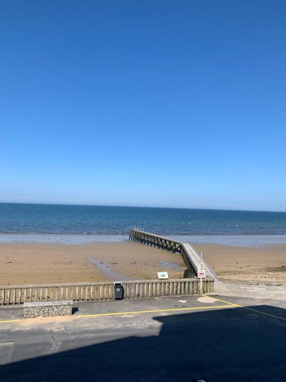 - une jetée sur une plage au bord de l'océan dans l'établissement Appartement front de mer, à Grandcamp-Maisy