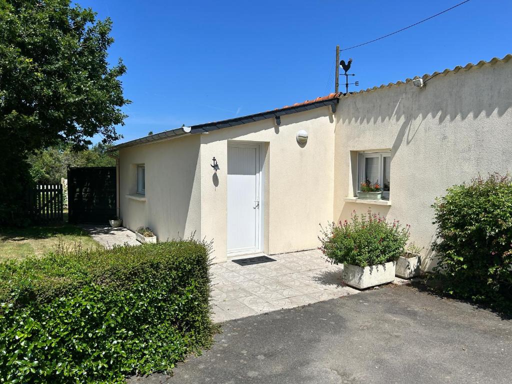 une petite maison blanche avec une porte blanche dans l'établissement 214 - Maison 4p à 2km de Sables-D'or-Les-Pins, à Plurien