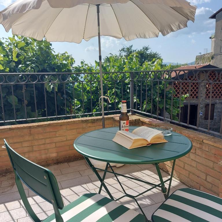 a table with an umbrella and an open book at Al Vecchio Lavatoio - Relax in collina in Colle Brianza