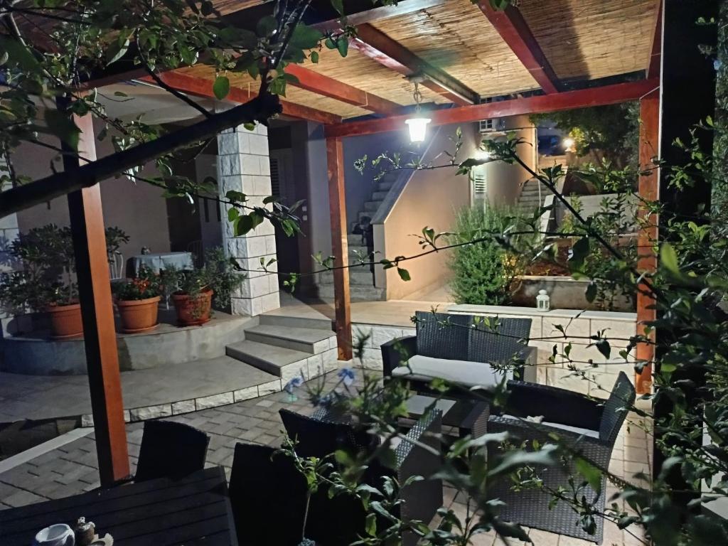 an outdoor patio with chairs and a pergola at House FIDULIC - apartment THE LAVENDER in Lumbarda