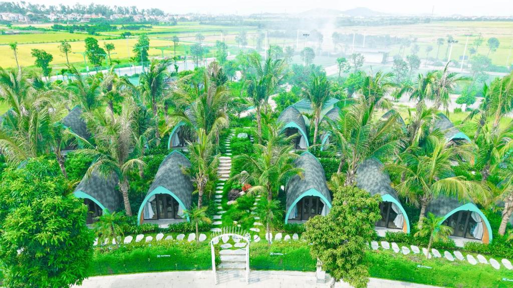 an aerial view of a resort with palm trees and huts at Xanh Melody Resort in Bắc Ninh