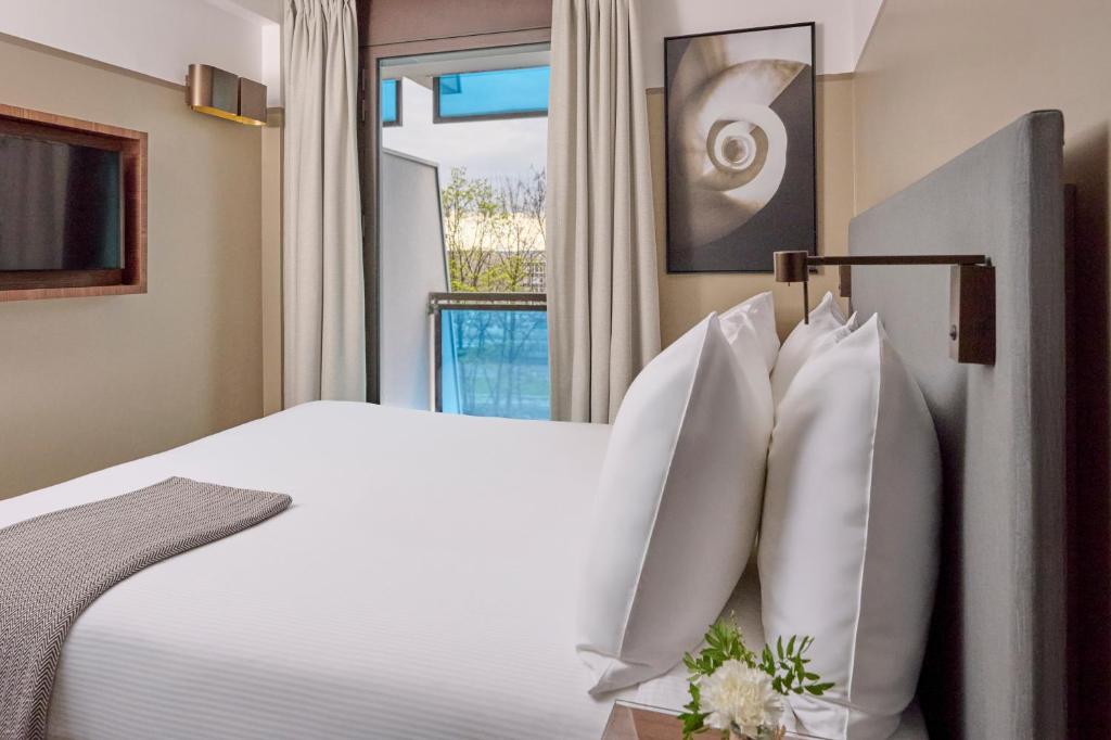 Un ou plusieurs lits dans un hébergement de l'établissement Fraser Suites Paris La Défense